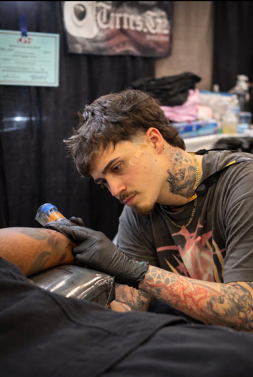 Justin Gossett tattooing at a convention